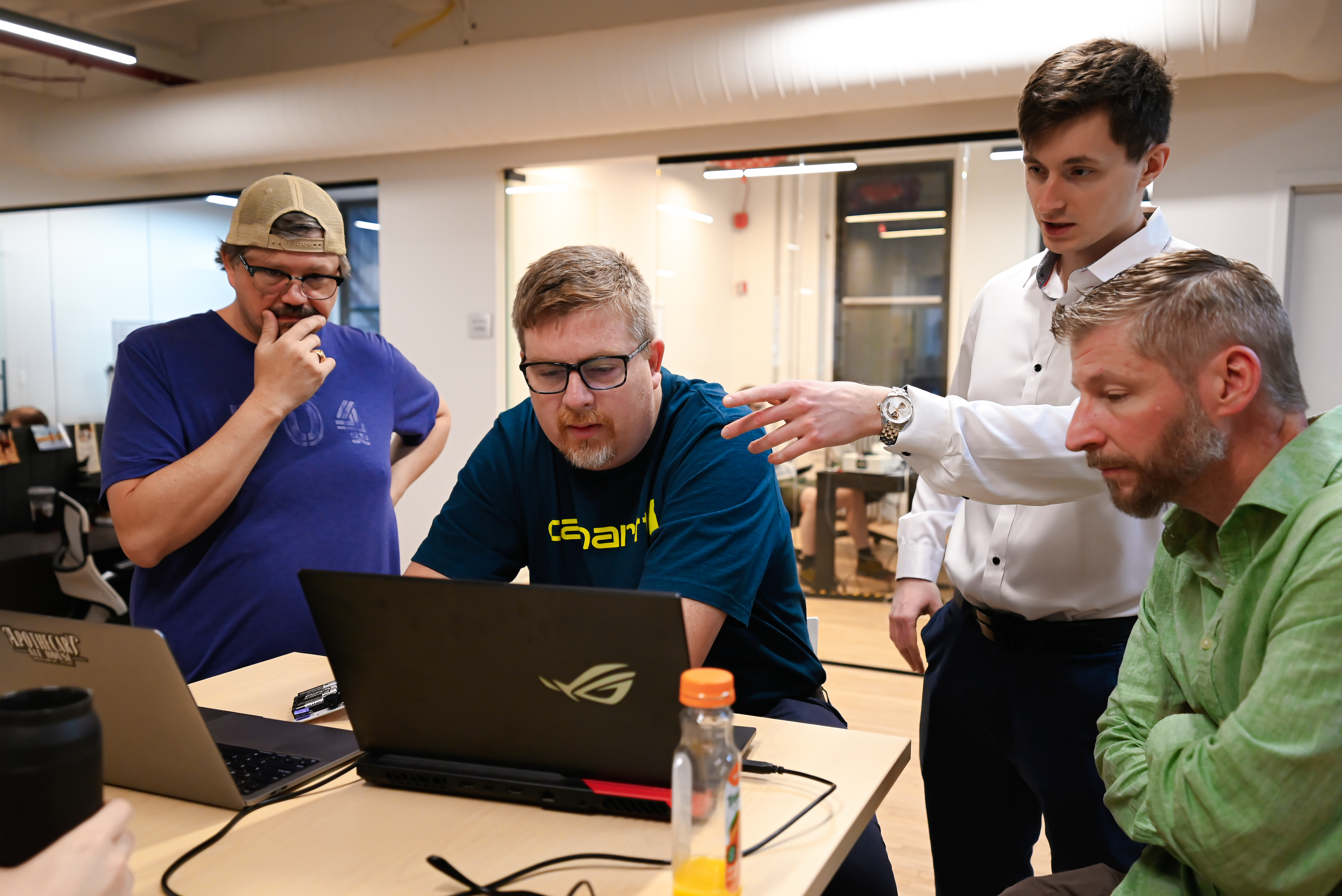 Team collaborating around laptops